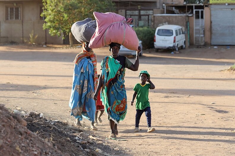 People flee their neighbourhoods amid fighting between the army and paramilitaries in Khartoum on April 19, 2023, following the collapse of a 24-hour truce