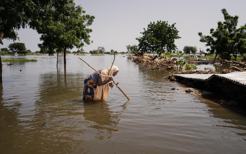 عظيمي أبو بكر ، 50 عامًا ، من سكان جاسامو ، يمشي في مياه الفيضان في  نيجيريا ، في 1 أكتوبر / تشرين الأول 2022. © WFP