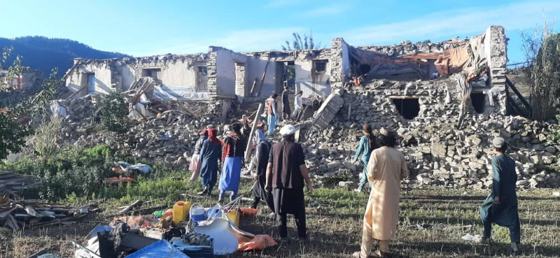 الناس في قرية بأفغانستان يقيّمون الأضرار التي لحقت بالمباني. الصورة: برنامج الأغذية العالمي/شير علي.
