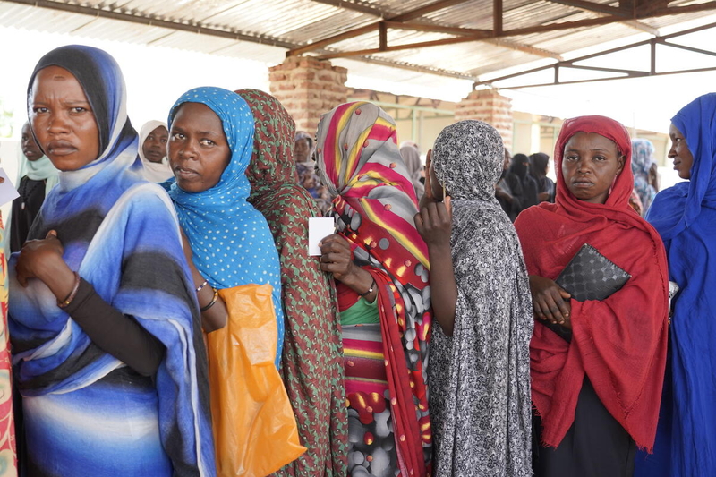 الصورة: برنامج الأغذية العالمي/ليني كينزلي. نساء ينتظرن في الطابور لتلقي التوزيعات النقدية.