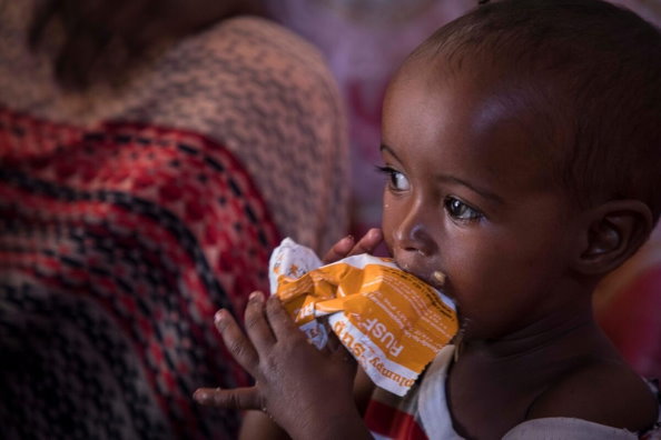 طفل يأكل مكملات غذائية لمعالجة سوء التغذية الحاد المتوسط. صورة: برنامج الأغذية العالمي/ماركو فراتيني