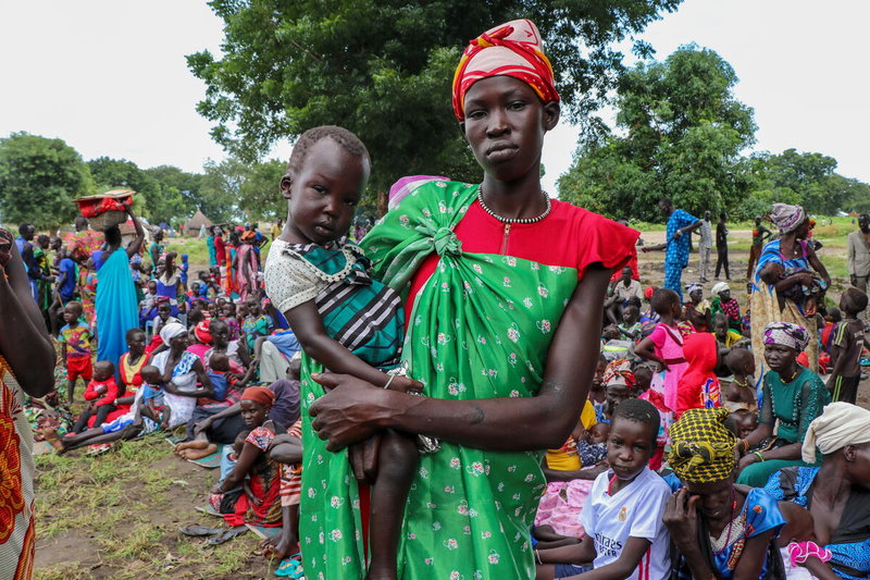 امرأة وطفل ينتظران التسجيل للحصول على مساعدات برنامج الأغذية العالمي. الصورة: برنامج الأغذية العالمي / يولاليا بيرلانجا. 