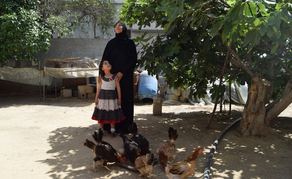 زينب تنظر بفخر إلى أمها المثابرة.  صورة: برنامج الأغذية العالمي/خالد أبو شعبان