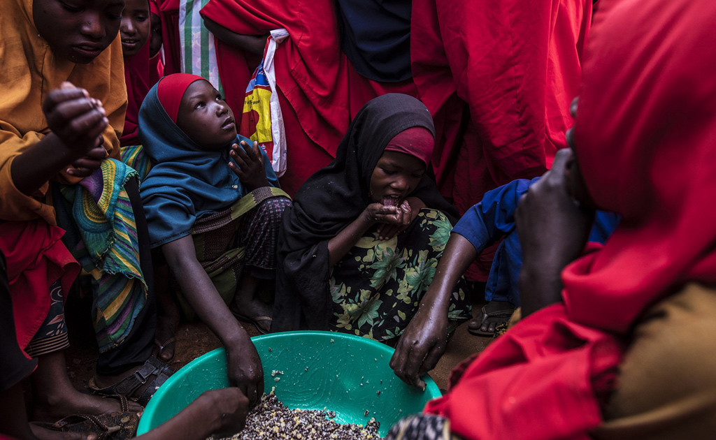 الفتيات يستمتعن بتناول الوجبة المدرسية التي يقدمها البرنامج في مخيم كاباسا في مدينة دولو، الصومال. صورة: برنامج الأغذية العالمي/جابريللا فيفاكوا
