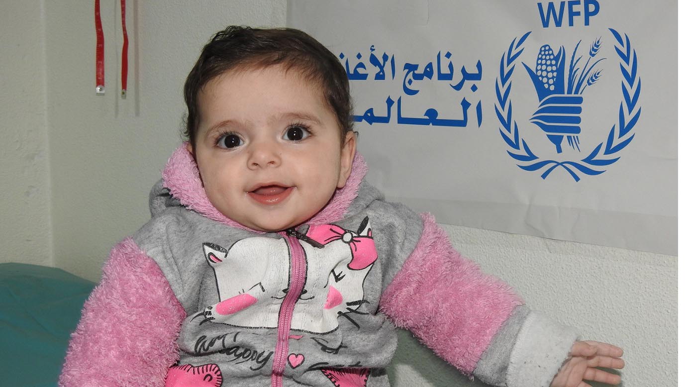 تبلغ نور من العمر 10 أشهر، وقد ازداد وزنها وأصبحت أكثر صحة. الصورة: برنامج الأغذية العالمي/زها عكاش