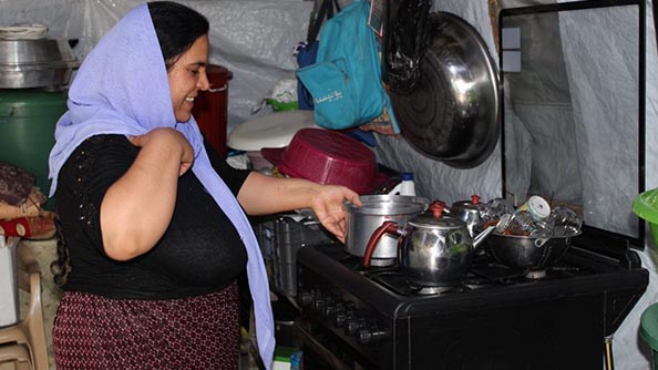نعم تحضر الغداء في مطبخها الصغير داخل الخيمة. الصورة: برنامج الأغذية العالمي/جورجيس نيسان.