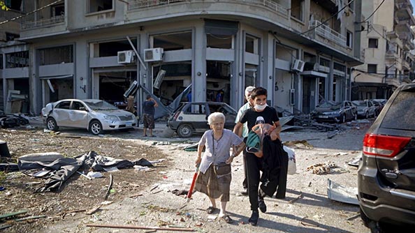 إجلاء سيدة من حي مار ميخائيل الذي تعرض للتدمير الجزئي في بيروت. الصورة: باتريك باز/وكالة فرانس برس