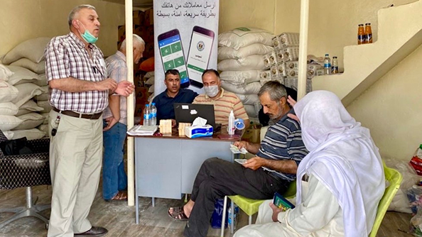 المواطنين في الموصل يستلمون البطاقات الخاصة التي تحتوي على رمز QR لتحميل تطبيق تمويني. الصورة: وزارة التجارة