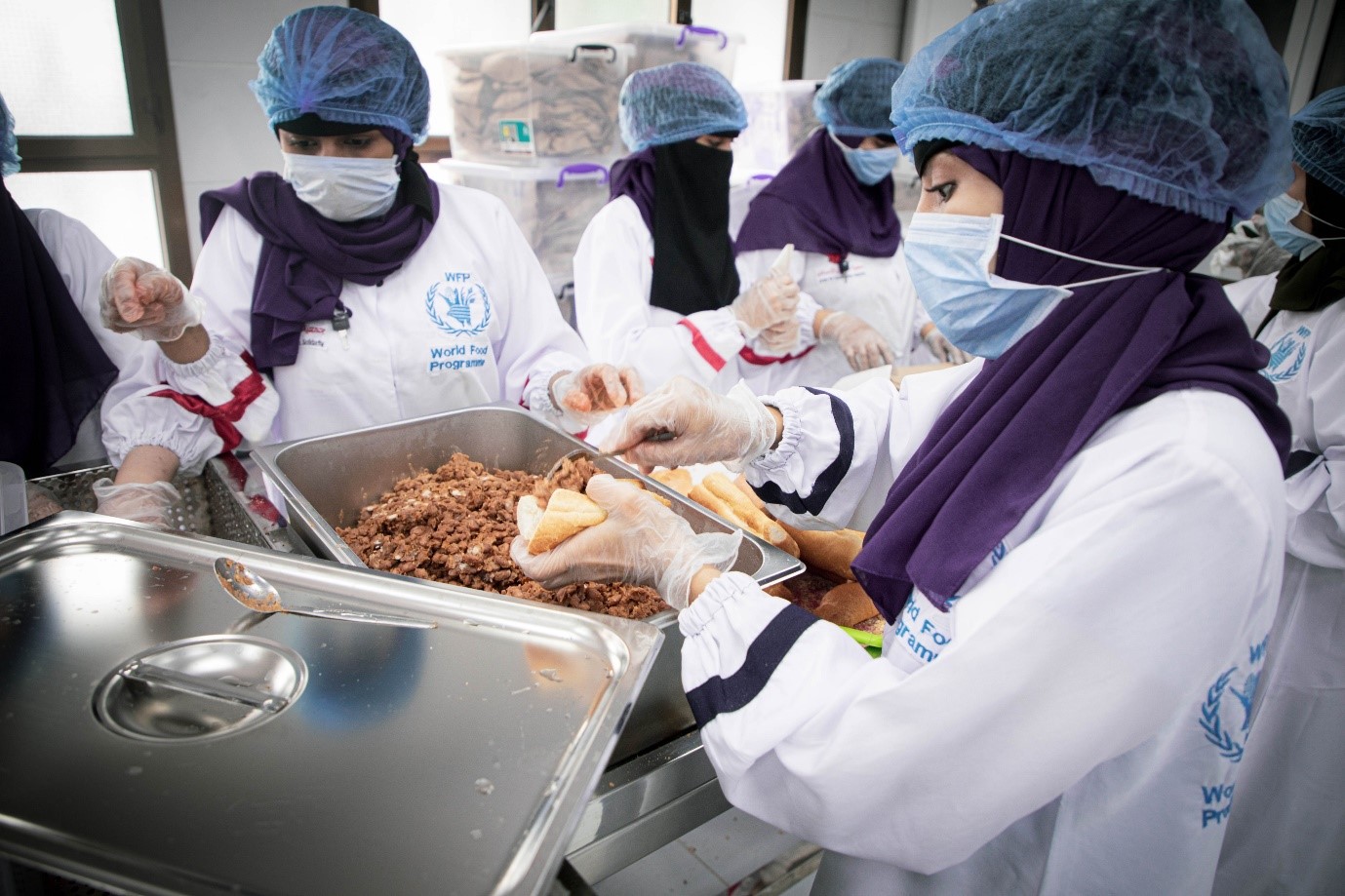النساء في المطبخ الذي يدعمه البرنامج يحضرن شطائر للغداء المدرسي. صورة: برنامج الأغذية العالمي/محمد ناشر