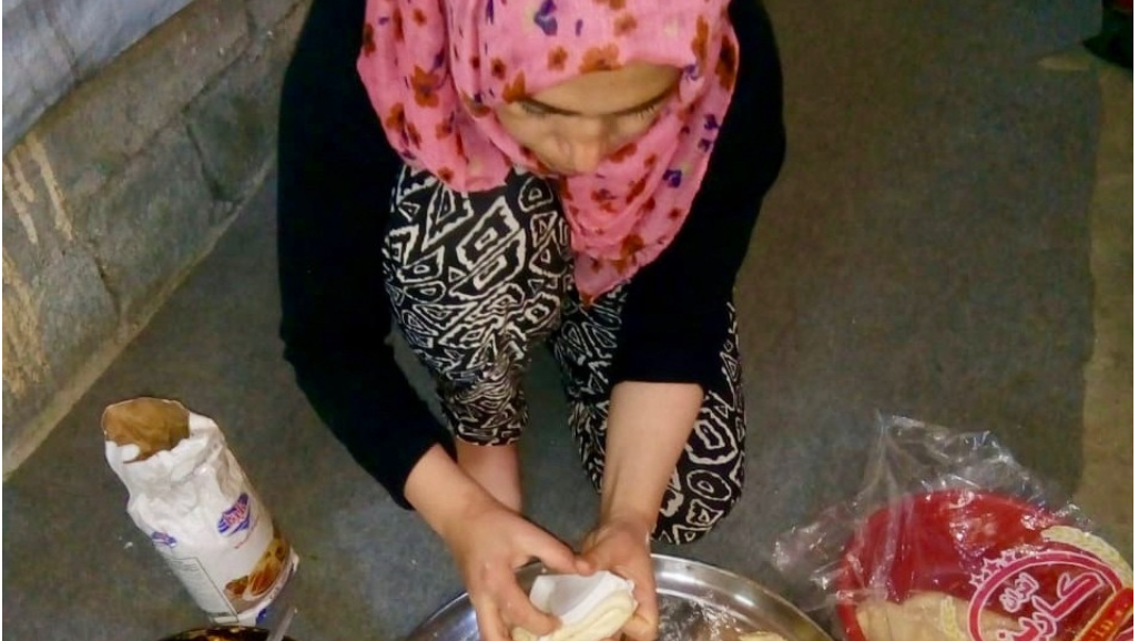 تقوم هدية بتجهيز وجبة الإفطار لأسرتها وفيها الأطباق السورية التقليدية. صورة: برنامج الأغذية العالمي/ شادي أحمد