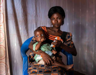 أم تعطي ابنها الأصغر كيونغو إيفاريست معجون الفول السوداني المغذي في كاليمي، جمهورية الكونغو الديمقراطية. الصورة: برنامج الأغذية العالمي/آريت/ فريدريك ليرنريد
