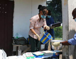 لويز أبايومي ، باحثة أولى بمركز (Postharvest)، قسم الأغذية والأسواق ، تقوم بإعداد الفوفو لأخذ عينات منها وتوضيح الكمية المناسبة التي يجب وضعها من الدقيق والماء والمغذيات للفريق الكونغولي. الصورة: برنامج الأغذية العالمي/أليس رحمون