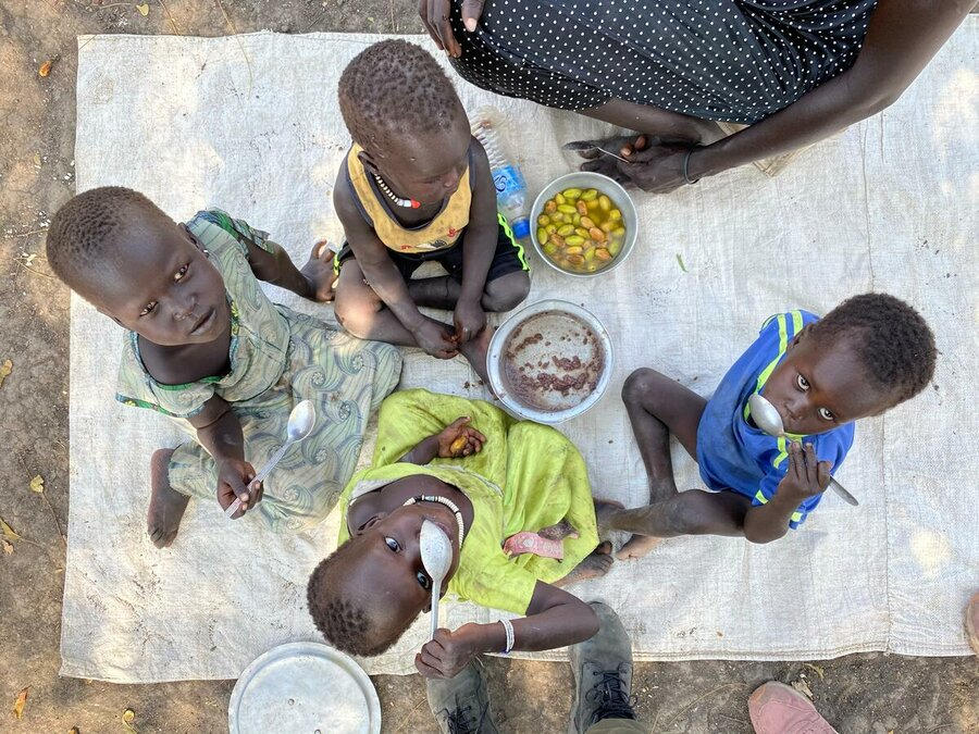 جنوب السودان: أطفال في أكوبو إيست، جونقلي، يتناولون وجبة غداء من الذرة الرفيعة مع فاكهة محلية- أُعلنت المجاعة آخر مرة في البلاد في عام 2017. الصورة: برنامج الأغذية العالمي / مروة عوض