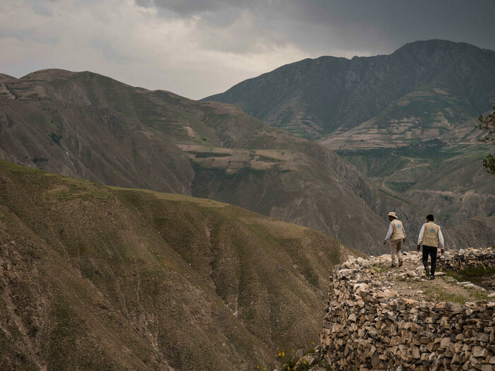 اثنان من موظفي برنامج الأغذية العالمي يسيران في الجبل