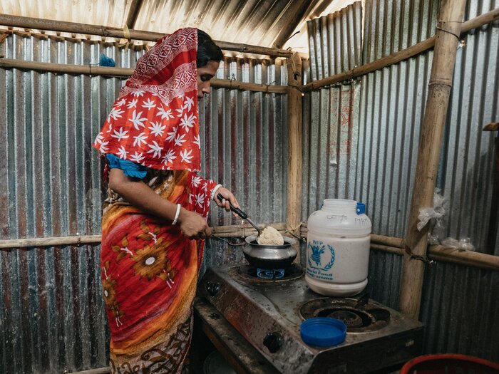 Woman cooking food items provided by WFP