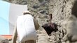 The back of a man carrying a bag of WFP food as he navigates earthquake rubble in eastern Afghanistan. Photo: WFP