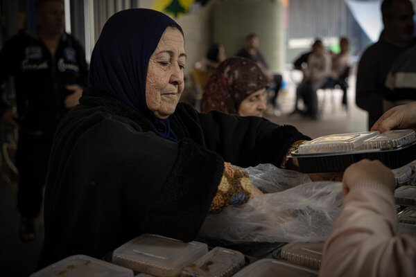 صورة: برنامج الأغذية العالمي/ماركو فراتيني، لبنان. توزيع مواد غذائية على عائلات نازحة تأوي إلى مدرسة حكومية في بيروت.