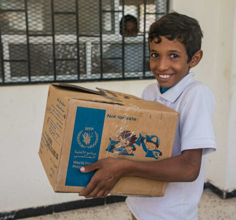 Boy with box of high energy biscuits in Yemen