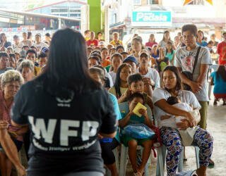 WFP staff explain the registration process to the members of Irosin community who are participating in the forecast-based financing project. Photo: WFP Philippines/Arete