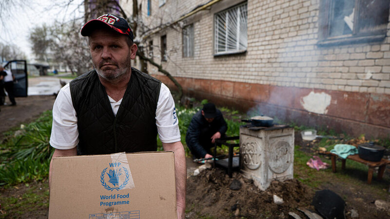 A man carries a WFP food ration into the Sievierodonetsk, hospital and bunker.