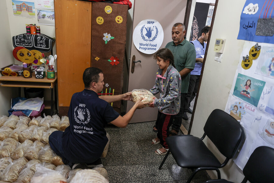 WFP staffer handing food to a child