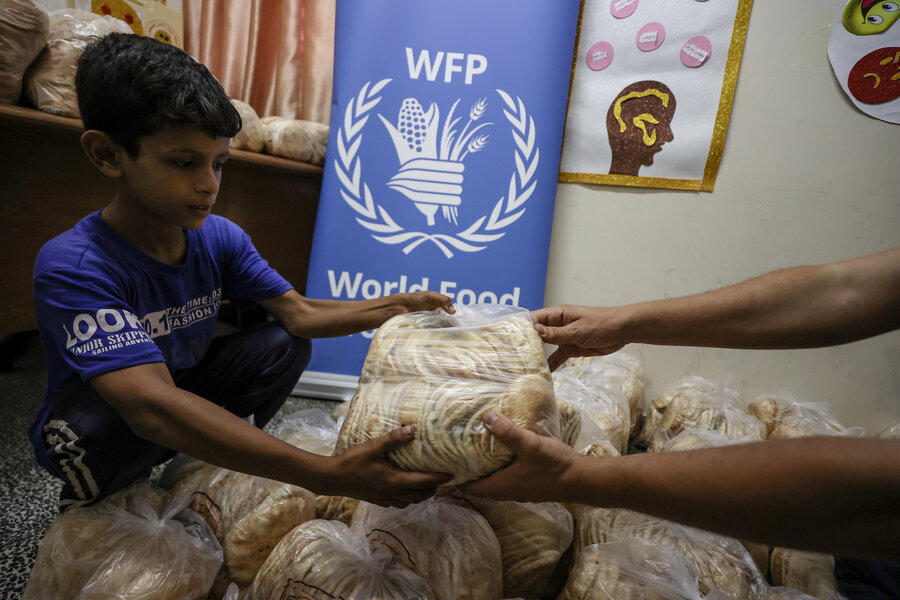 A young boy being handed bread