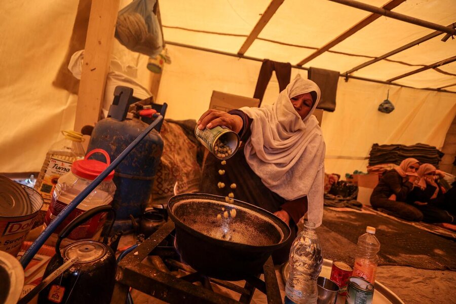 A woman cooks for her family at camp for displaced people in southern Gaza. Photo: WFP/Ali Jadallah