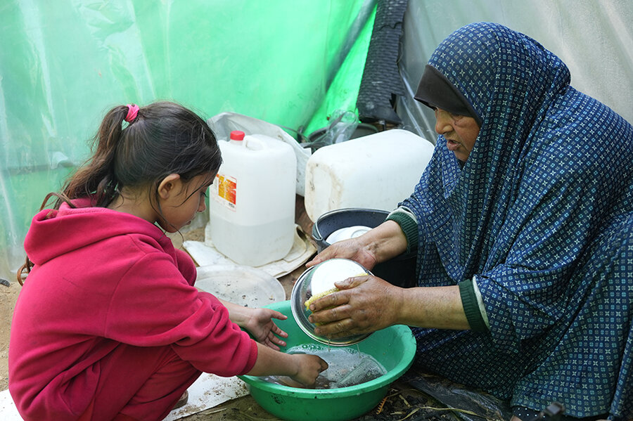 Abla washing dishes with her daughter