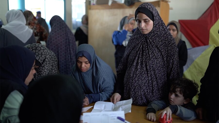 Muna collects WFP's specialized nutritious paste for her daughter, whom she breastfeeds. Photo: WFP/Mostafa Ghroz