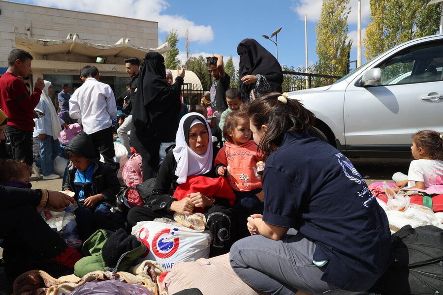 WFP staffer talking to a woman with a child