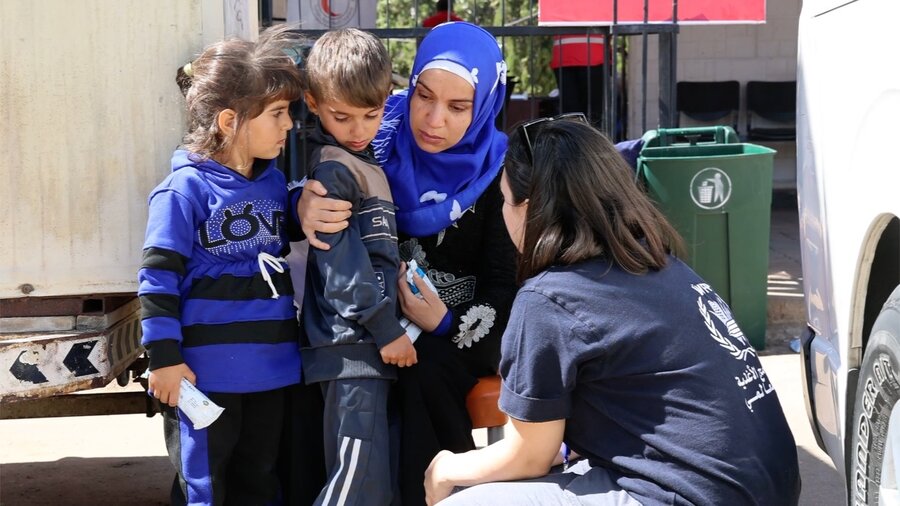 A WFP employee speaks to displaced people from Lebanon, where the conflict has uprooted more than a million people so far. Photo: WFP/Mohammed Awadh