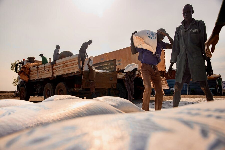 Men unload bags of food in South Sudan, where hunger and malnutrition are soaring. Photo: WFP/Samantha Reinders