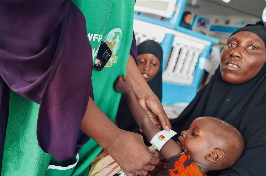 Ali holds her daughter Ruqiya, as a health worker measures her mid-upper arm circumference with a special band. It shows she's nearing severe malnutrition. Photo: WFP/Sara Cuevas Gallardo