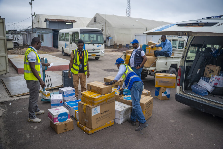 Workers in blue and yellow vests load boxes onto a waiting vehicle. Photo: WFP/Michael Castofas