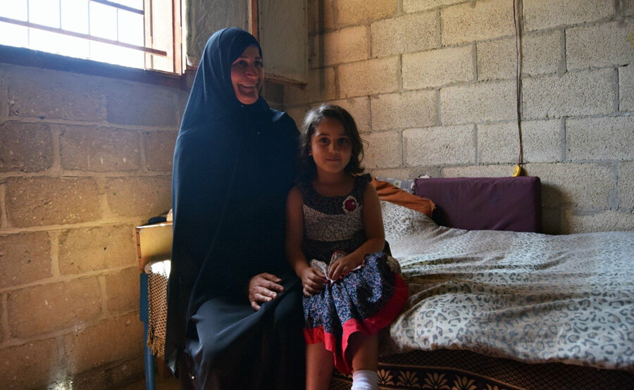 عزة، 45 سنة، مع ابنتها الصغرى زينب، 5 سنوات في منزلهما في خان يونس، قطاع غزة. الصورة: برنامج الأغذية العالمي/خالد أبو شعبان