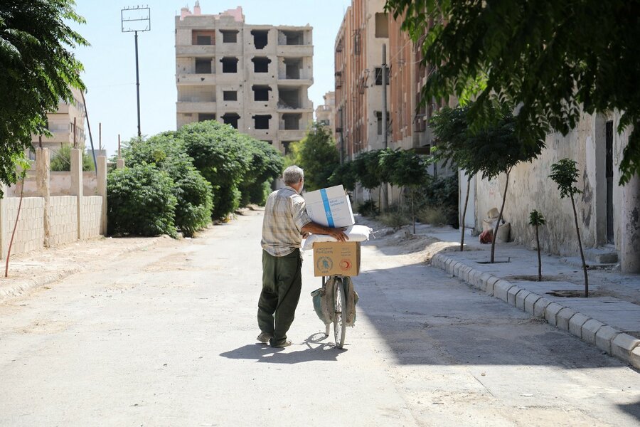 أبو طارق في طريق عودته وهو يحمل الأغذية التي أحضرها لأسرته. الصورة: برنامج الأغذية العالمي/ حسام الصالح