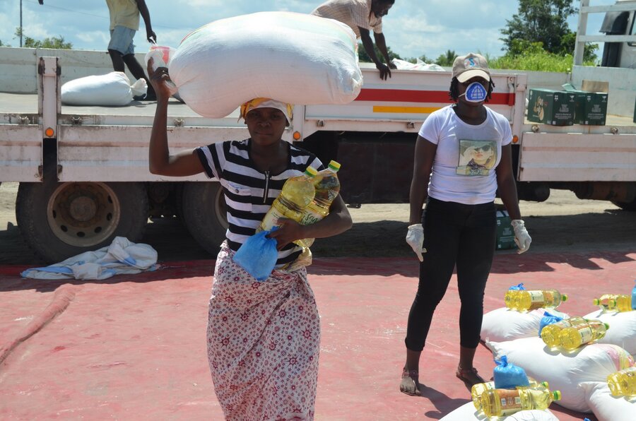موزمبيق: امرأة تتسلم أغذية تكفيها لمدة شهر من مركز لإعادة التوطين في سافان - تقلل الإمدادات الكافية من فرص التزاحم حيث لا يحتاج الناس إلى العودة للحصول على المواد الغذائية. الصورة: برنامج الأغذية العالمي/رافائيل كامبوس
