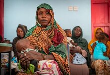 الصورة: برنامج الأغذية العالمي/أبو بكر جار النبي، طفلة تنام بين يدي والدتها أثناء انتظار دورها لإجراء القياسات في المركز الصحي الذي يدعمه برنامج الأغذية العالمي في بورتسودان.