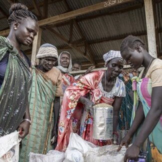 نساء يحملن مساعدات غذائية في جنوب السودان.
