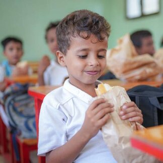 طفل يمني يأكل ساندوتش في المدرسة