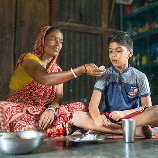 Shefali Sarkar is feeding her ten year old son Bijoy Sarkar. WFP/Sayed Asif Mahmud