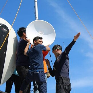 Group of men setting up a satellite dish