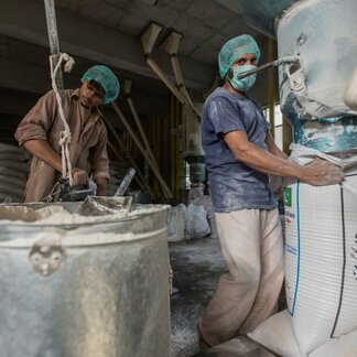 Two men working in a processing plant. Photo: WFP/Rein Skullerud