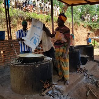 Woman cooking school meals in a kitchen.