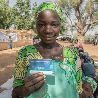 Woman showing her voucher card. Photo: WFP/Simon Pierre Diouf